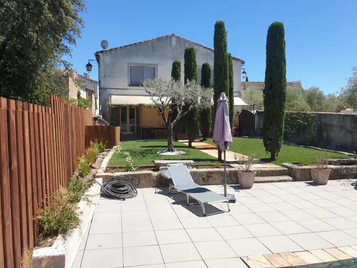 Jardin clos avec gazon, olivier, cyprès et terrasse carrelée