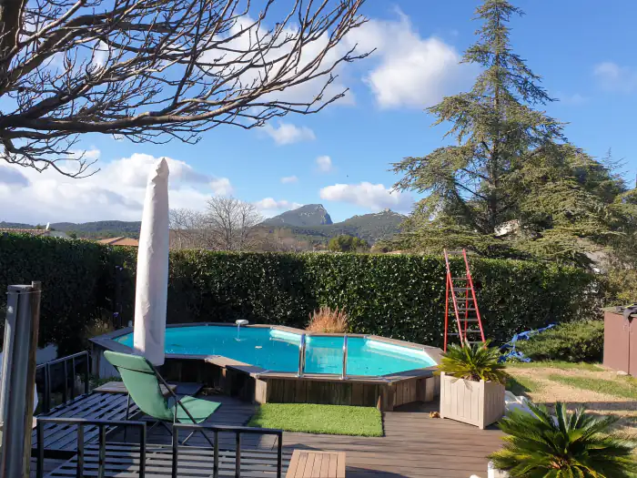 Piscine en bois hors-sol et terrasse avec vue sur les collines